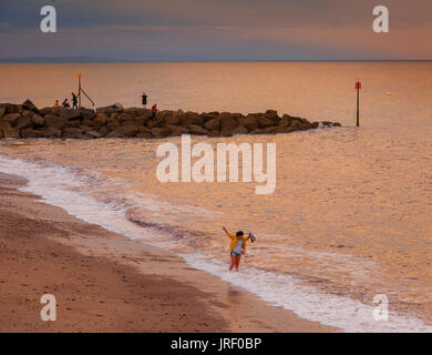 La ville de Sidmouth, Devon, UK. 4 août 2017. Météo britannique. Une femme jouit d'une palette dans la mer au coucher du soleil à Sidmouth. Demain (Samedi) voit le début de la totalité du programme de la semaine, le Folk Sidmouth folk festival a été lancé en 1955, attire des dizaines de milliers de visiteurs, et, plus de 700 événements avant le concert final le 11 août. Credit : Sud Ouest Photos/Alamy Live News Banque D'Images