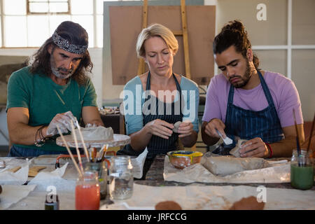 Avec les élèves de l'enseignant de faire les produits en argile, en position assise, dans la classe d'art Banque D'Images