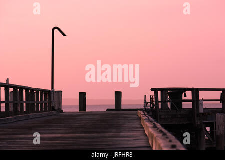 Coucher de soleil rose sur la jetée en bois teintes wharf sur Fraser Island Queensland Australie Banque D'Images