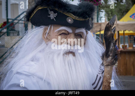 Homme dans un à trois coins de la hat et longue barbe blanche et masque à une foire de la Renaissance dans le sud de la France Banque D'Images