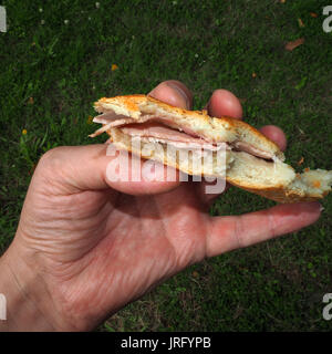 Man holding baguette au jambon Banque D'Images