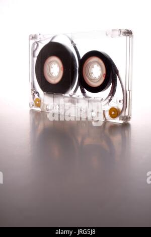 Cassette audio en cours sur un fond blanc rétroéclairé Banque D'Images