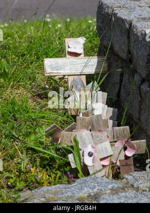 Coquelicots et décoloration croix de bois qui ont été laissés sur le monument commémoratif de guerre à Warsash Road, Warsash, Angleterre Banque D'Images