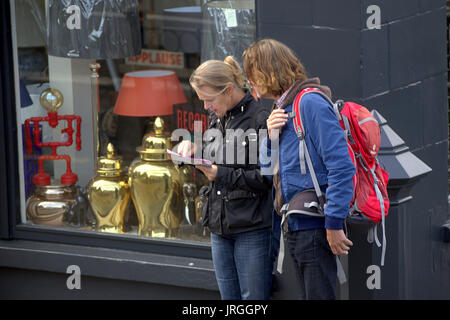 Les touristes d'examiner un site perdu de Great Western Road Glasgow Ecosse couple homme femme Banque D'Images