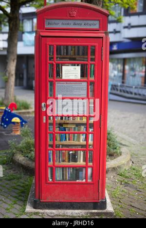 La vieille cabine téléphonique en veilleuse livre Banque D'Images