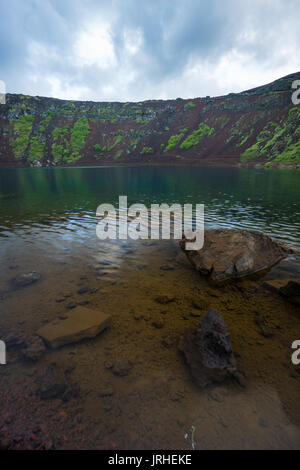 Islande - les pierres dans l'eau bleu clair au lac de cratère Kerid Banque D'Images