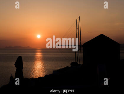 Coucher de soleil sur l'île de Sikinos pris d''Oia avec la voile d'un moulin, Santorini, Grèce Banque D'Images