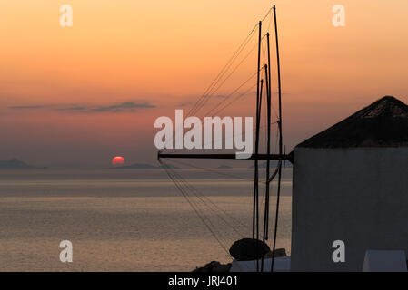 Coucher de soleil sur l'île de Sikinos pris d''Oia avec la voile d'un moulin, Santorini, Grèce Banque D'Images