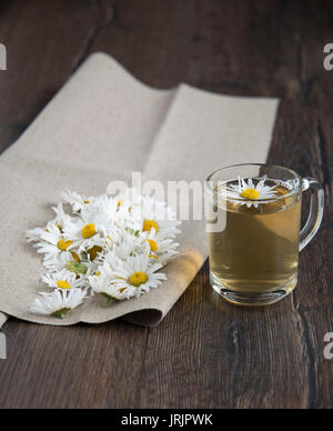 Camomille et fleurs de camomille se trouvent sur un tissu de jute Banque D'Images