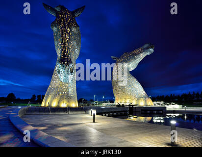 Les Kelpies, 30 mètres de haut sculptures à tête de cheval illuminée la nuit se reflétant dans le Forth and Clyde Canal au parc Helix près de Falkirk. Banque D'Images