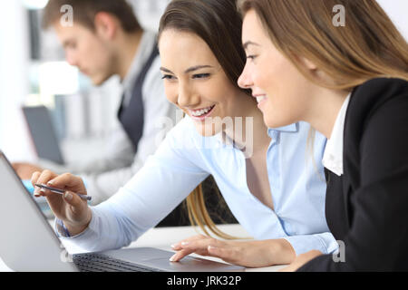 Deux femmes travaillant ensemble à la ligne avec un laptop at office Banque D'Images