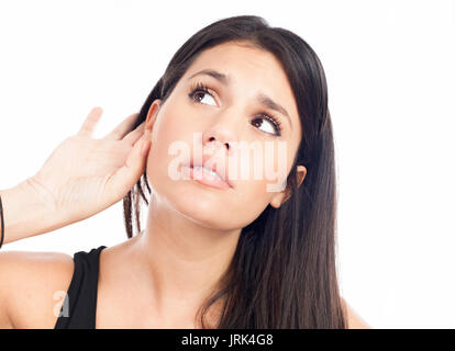 Jeune femme essayant d'écouter quelque chose Banque D'Images