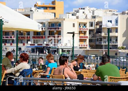 Les touristes se détendre à la terrasse d'un cafe au printemps, Bugibba, Malte, l'Europe. Banque D'Images