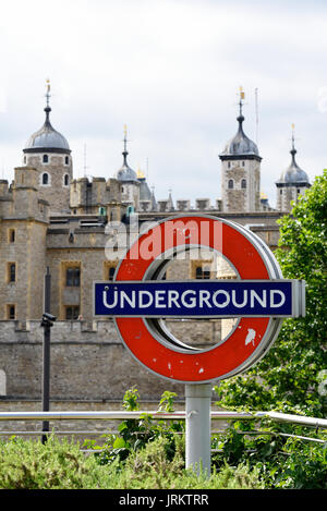 Panneau de métro londonien à la station Tower Hill avec la Tour de Londres au-delà Banque D'Images