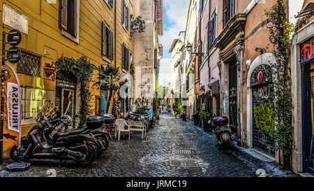 Ruelles pittoresques retour street dans le Trastevere de Rome Italie avec des magasins et les motos garées Banque D'Images