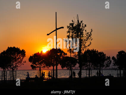 Silhouettes de personnes qui marchent à Thessalonique de neuf au coucher du soleil au bord de l'eau Banque D'Images