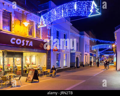 Les gens de rue la nuit avec café Costa et lumières de Noël, Galles, Royaume-Uni Banque D'Images