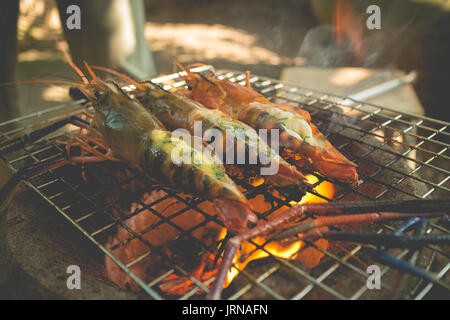 Crevettes grillées avec du beurre et de la rivière d'herbe sur flaming grill Banque D'Images