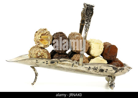 Plateau d'argent avec des truffes au chocolat belge isolé sur fond blanc Banque D'Images