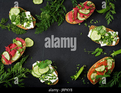 Variété de sandwichs sains sur un fond sombre dans un style rustique. Vue d'en haut. Mise à plat Banque D'Images