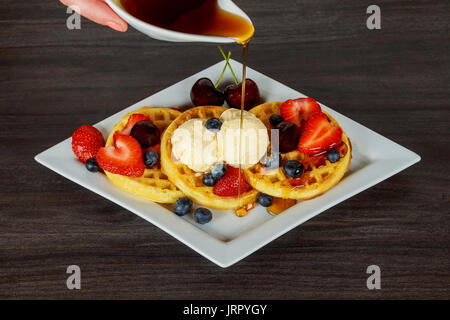 Gaufres avec les baies fraîches, crème fouettée et la crème glacée avec des gaufrettes de fraises et de bleuets de la crème glacée Banque D'Images