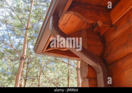 Système de gouttières de toit sur log house in forest Banque D'Images