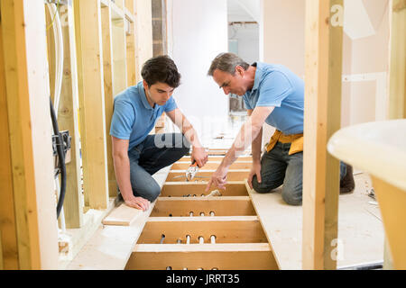 Apprenti plombier et installation du chauffage central Banque D'Images