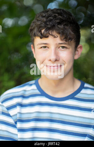 Portrait Of Happy Young Boy Sitting Outdoors Banque D'Images