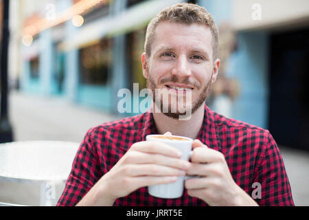 Portrait de jeune homme de boire du café au café en plein air le tableau Banque D'Images