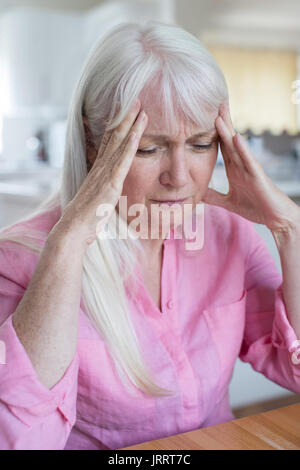 Femme mature à la maison souffrent de maux de tête Banque D'Images