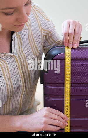 Close Up of Woman Measuring valise avant Maison de Vacances Banque D'Images