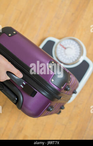 Portrait de femme pesant sur valise Échelle avant Maison de Vacances Banque D'Images