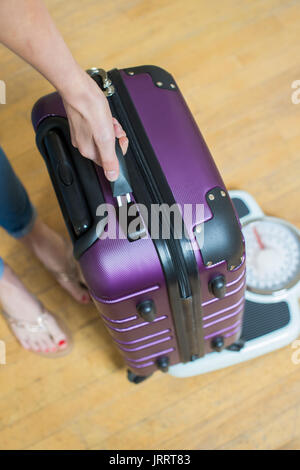 Portrait de femme pesant sur valise Échelle avant Maison de Vacances Banque D'Images