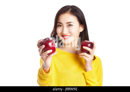 Jeune et belle femme asiatique montrant deux pommes rouges, isolé sur fond blanc, concept de saine alimentation. Banque D'Images