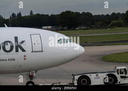 Thomas Cook un Airbus A330-243 est tiré par un remorqueur camion à London Stansted Airport Banque D'Images