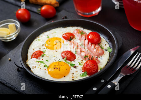 Petit-déjeuner anglais - œuf frit, tomates et saucisses. Banque D'Images