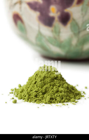 Tas de thé matcha vert avec une tasse de thé sur l'arrière-plan Banque D'Images