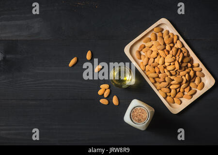 Les amandes dans la plaque et bouteille de lait sur fond de bois. Les écrous d'amande. Banque D'Images