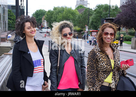 Trois woman posing sur Battersea Bridge, Londres. Banque D'Images