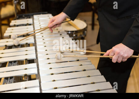 Xylophone, instrument à percussion concept - gros plan sur les barres en bois avec quatre maillets de mains humaines, de l'interprète en robe noire, glockenspiel, concert de l'orchestre, l'art de la musique, selective focus. Banque D'Images