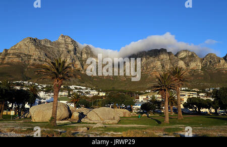 Les nuages se forment sur le dessus de la Montagne de la table, et les douze apôtres comme vu au coucher du soleil de la plage de Camps Bay à Cape Town, Western Cape, Afrique du Sud. Banque D'Images