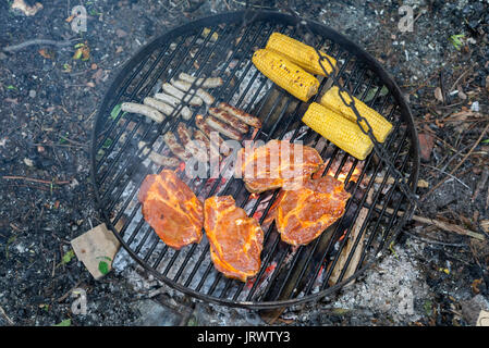 Viande, saucisses et épis de maïs sur le grill fire Banque D'Images