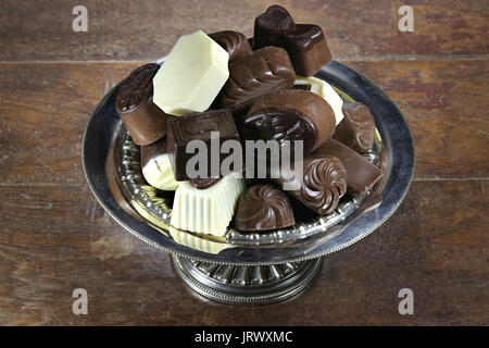 Chocolat pralines belge dans un bol en argent sur fond de bois rustique Banque D'Images