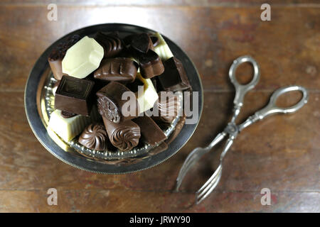 Chocolat pralines belge dans un bol en argent sur fond de bois rustique Banque D'Images