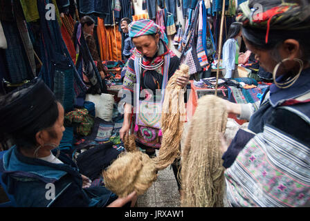 Les femmes hmong noirs de fabriquer et de vendre des vêtements et de l'artisanat tribal iniside le marché de Sapa, province de Lao Cai, Vietnam Banque D'Images