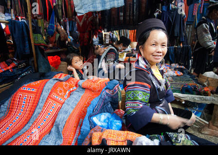 Les femmes hmong noirs de fabriquer et de vendre des vêtements et de l'artisanat tribal iniside le marché de Sapa, province de Lao Cai, Vietnam Banque D'Images