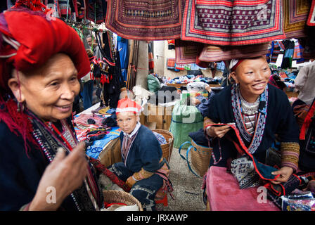 Dao rouge femmes hmong fabriquent et vendent des vêtements et de l'artisanat tribal iniside le marché de Sapa, province de Lao Cai, Vietnam Banque D'Images