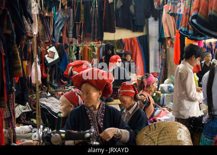 Dao rouge femmes hmong fabriquent et vendent des vêtements et de l'artisanat tribal iniside le marché de Sapa, province de Lao Cai, Vietnam Banque D'Images