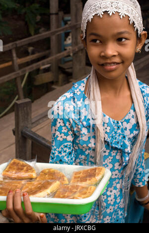 Une jeune fille vend des gaufres fraîches sur les canaux près de Phong Dien. Delta du Mekong, Vietnam Banque D'Images