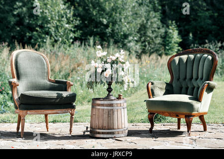 Chaises et table en bois vintage avec décoration de fleurs jardin en plein air. Banque D'Images